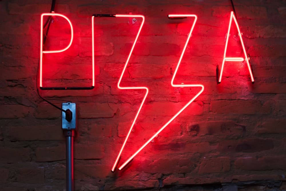 Lichtgevende letters die in het rood het woord pizza vormen