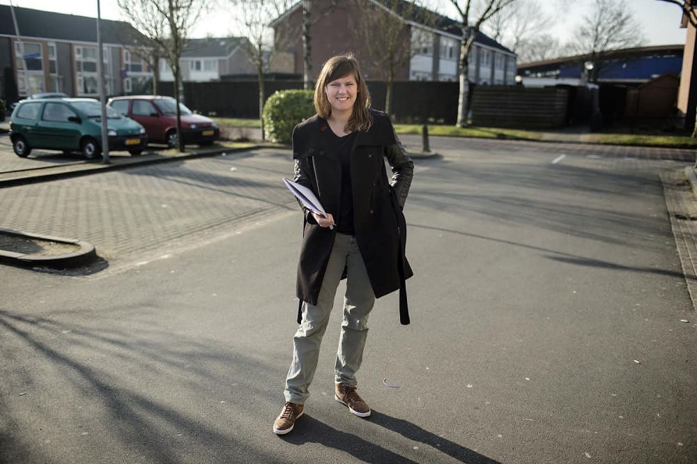 Een lachende Maaike Wind op straat, symbolisch voor dat ze op de helft is van het aflossen van haar studieschuld