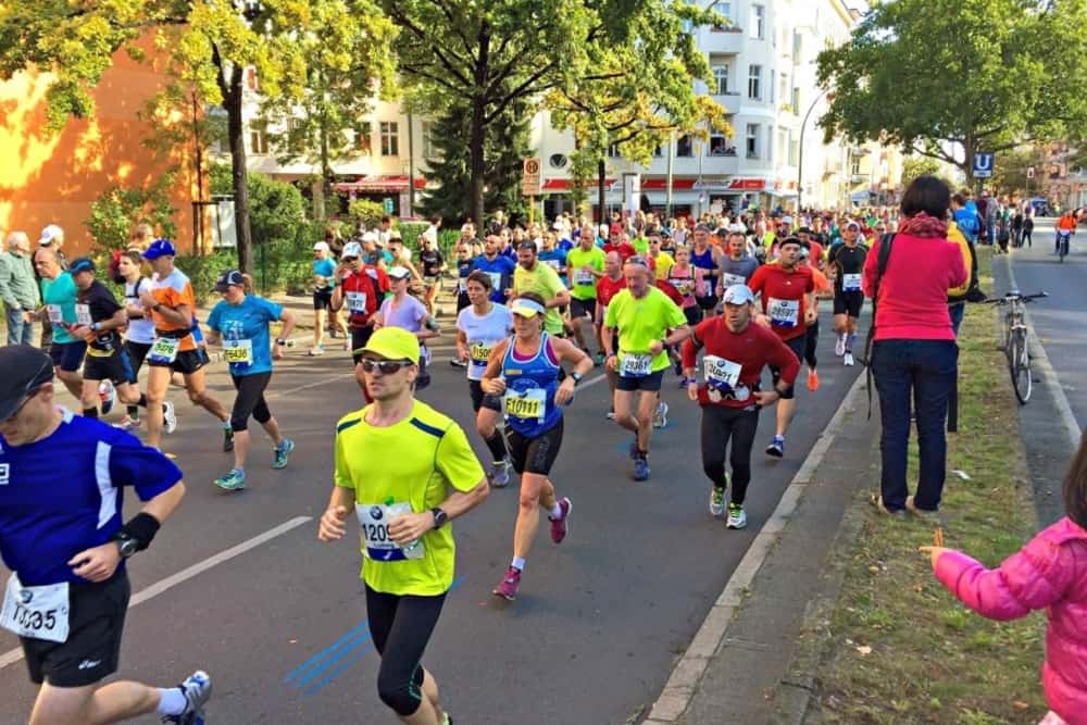 Een lint van gekleurde shirts bij kilometer 22 van de marathon in Berlijn in 2015