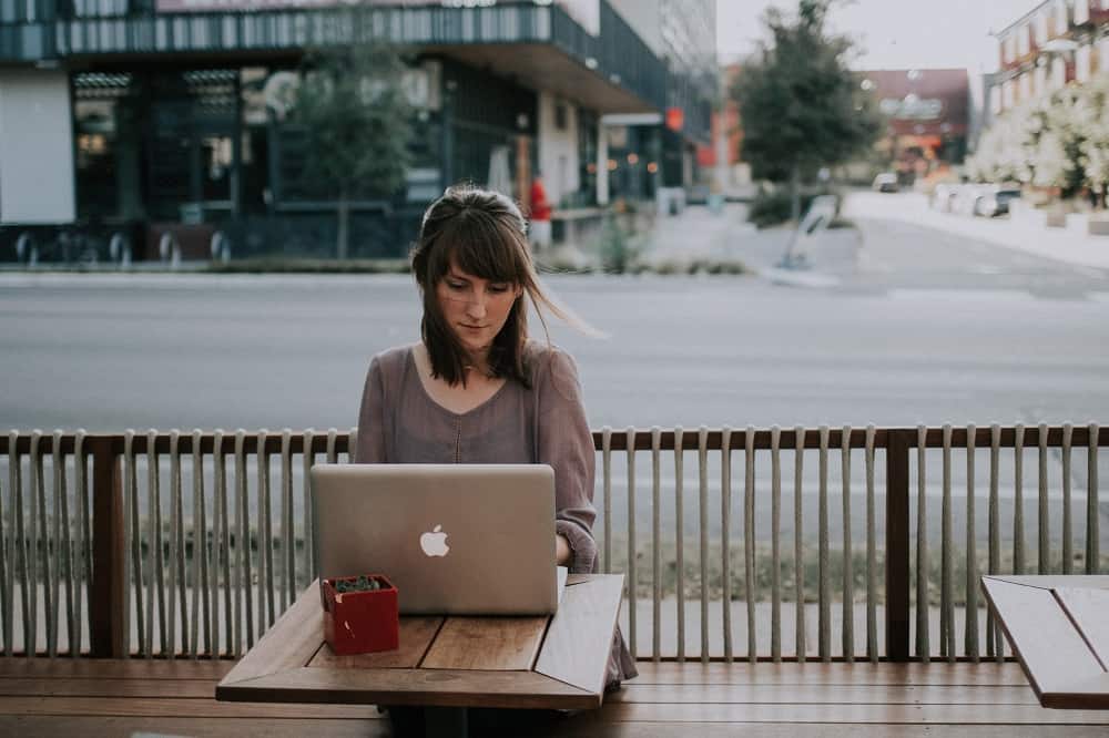 Een vrouw zit achter een laptop, wellicht is ze haar BKR aan het opvragen.