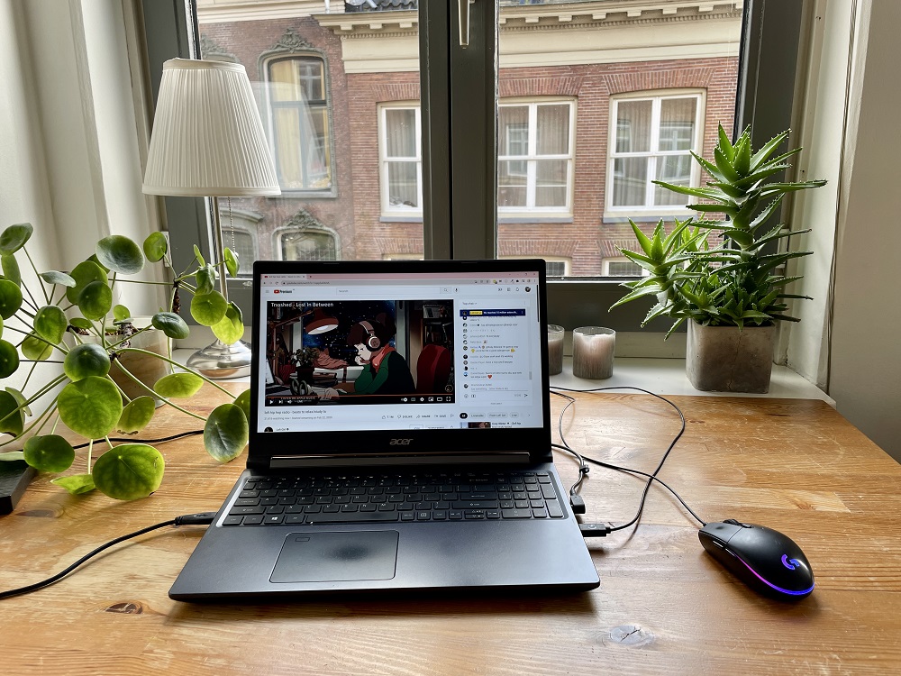 M'n bureau voor het raam met daarop m'n laptop met YouTube (YouTube is gratis en zo fijn)